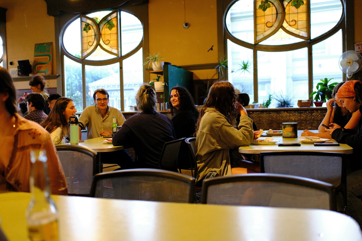 Restaurant staff team meeting discussing employee retention strategies and workplace improvements in modern hospitality setting