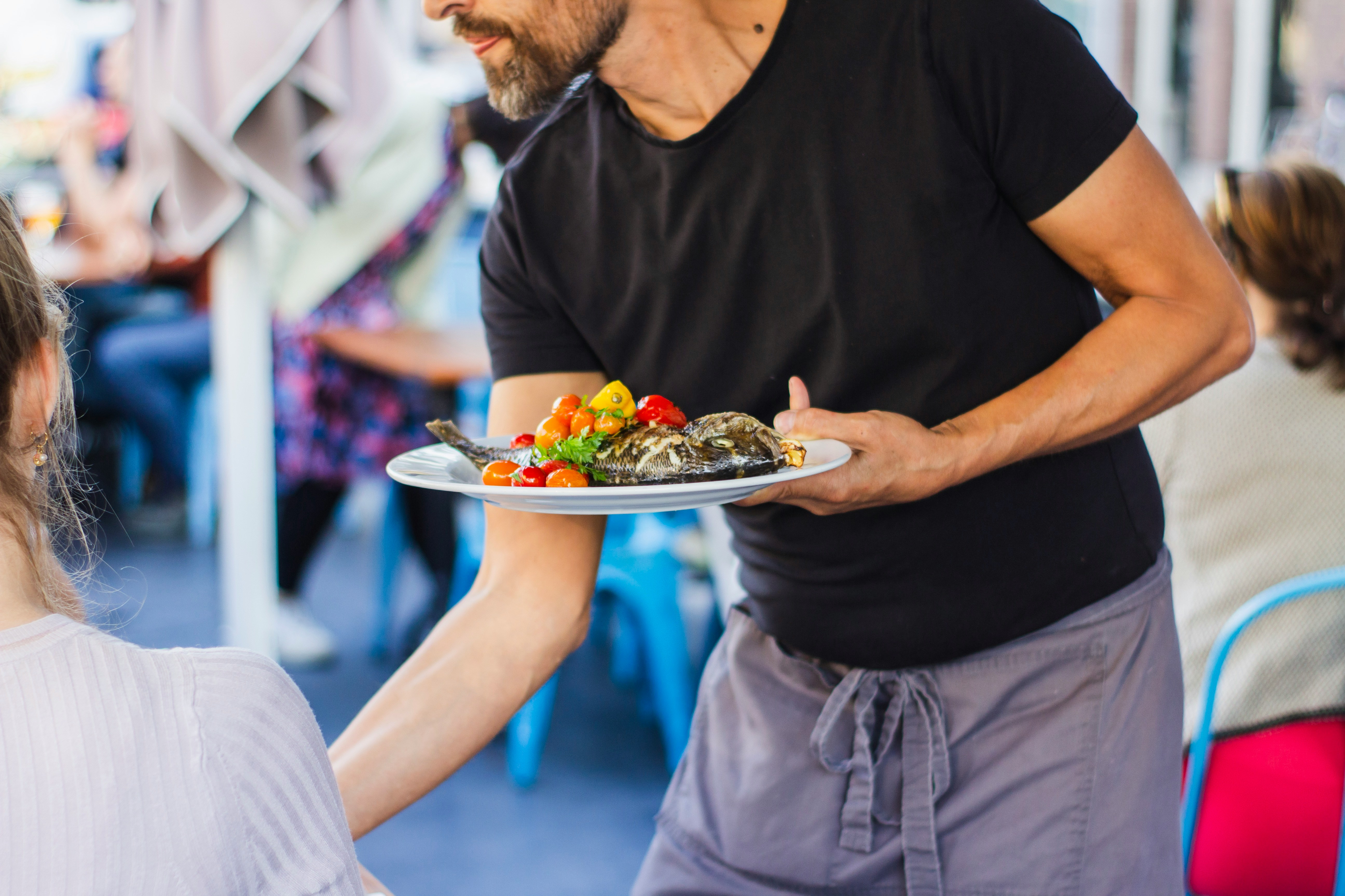 Professional server greeting customers with a warm smile and confident posture, demonstrating perfect first impression techniques